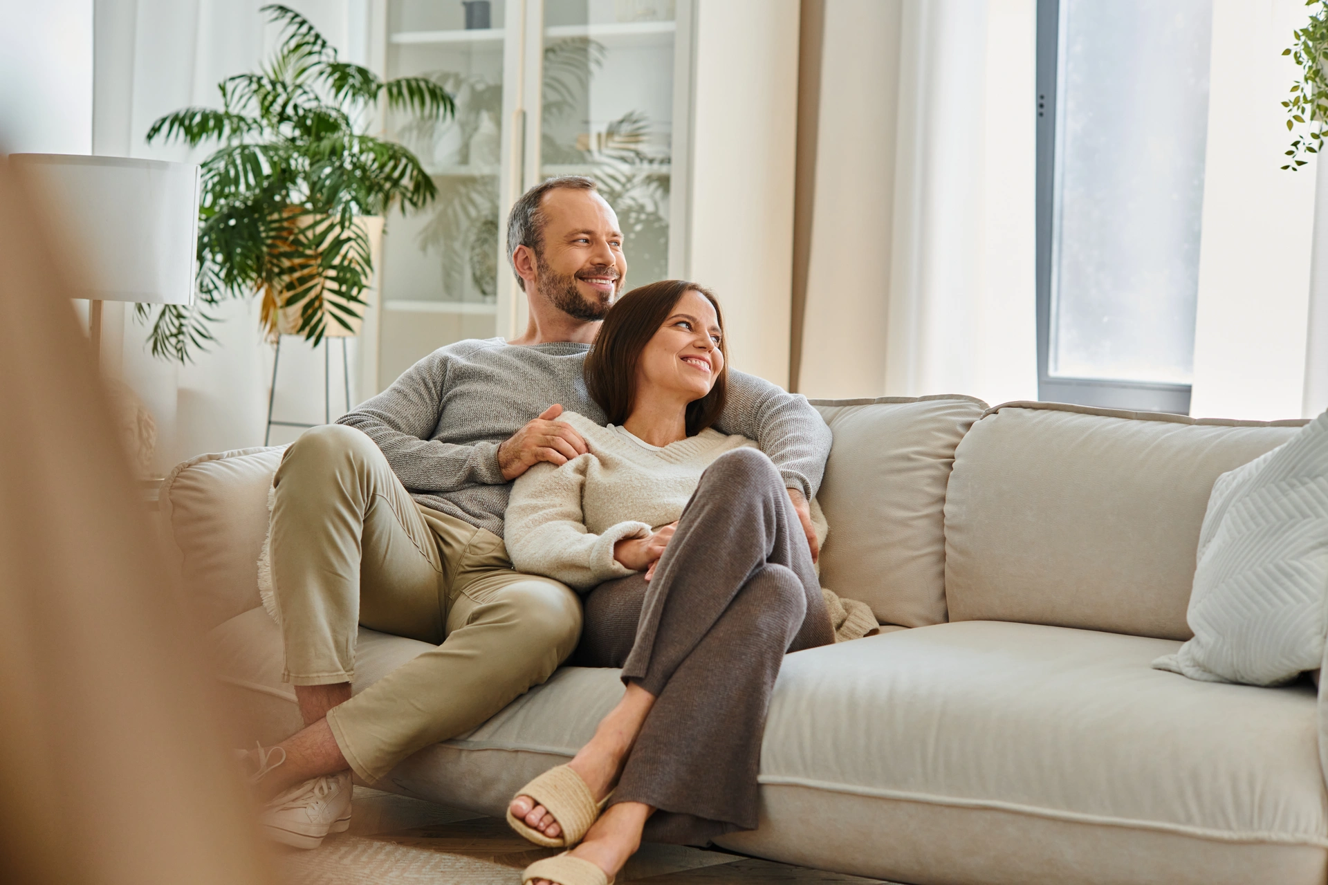 Paar sitzt entspannt auf einem Sofa im Wohnzimmer
