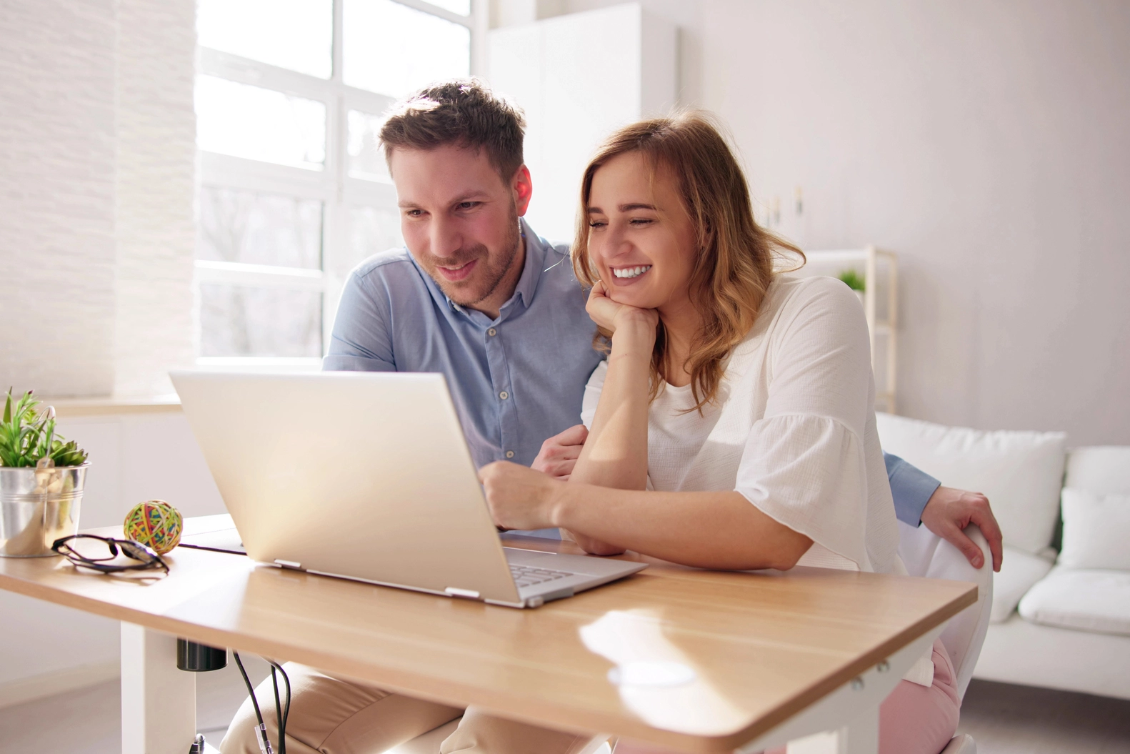Lupe und Hausmodell als Motiv für die Immobiliensuche